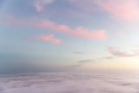 Soft pink clouds above a sea of white cloud