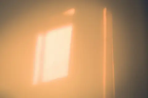 A square of warm sunlight falling on a plain wall