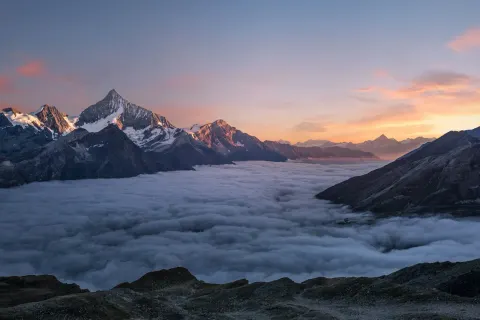 Snowy mountain peaks above cloud layer