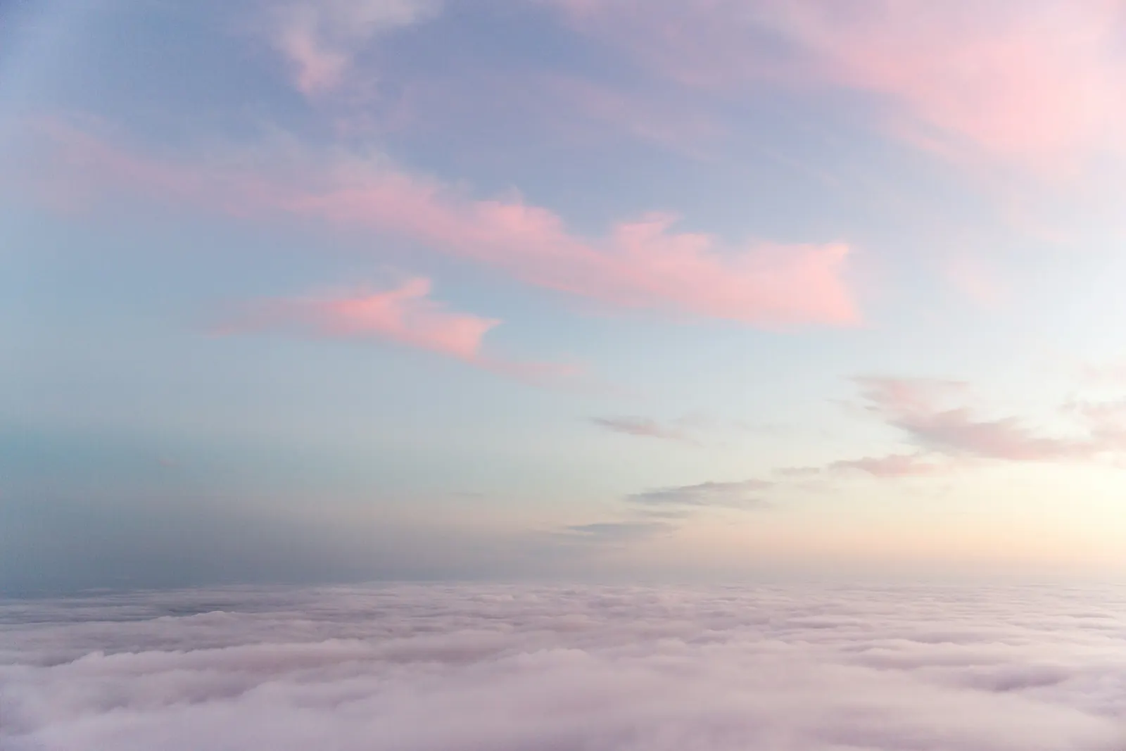 Soft pink clouds above a sea of white cloud