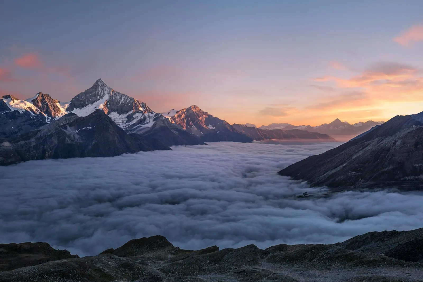 Snowy mountain peaks above cloud layer
