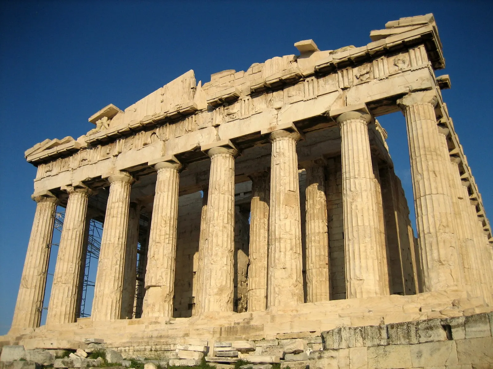 Ancient marble temple columns on a rocky acropolis under blue sky